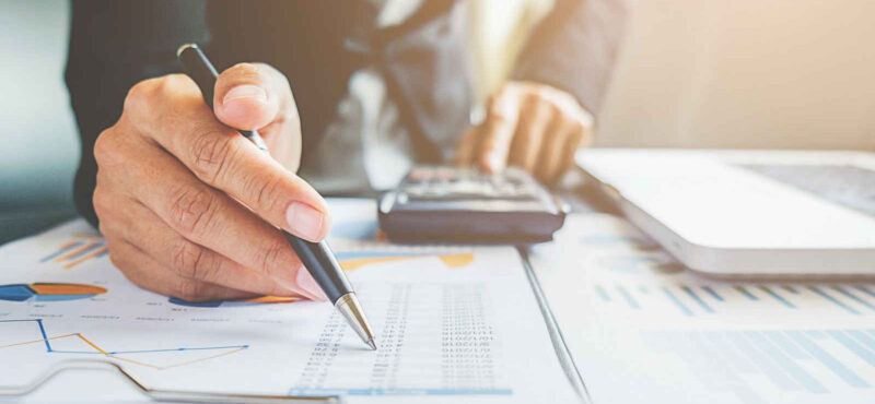 An accountant goes over a paper ledger.